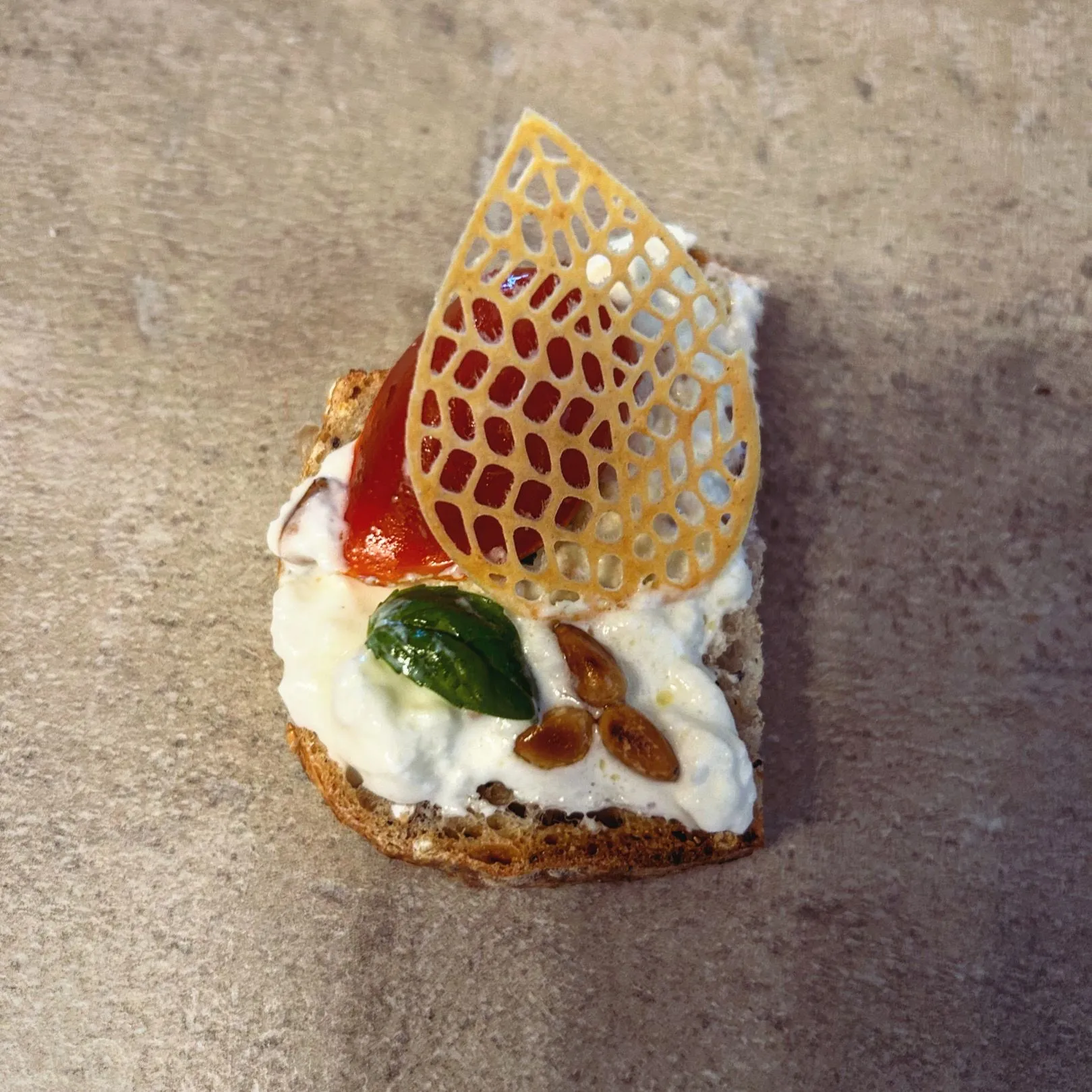 Canapé gastronomique au fromage frais, tuile et basilic, amuse-bouche traiteur